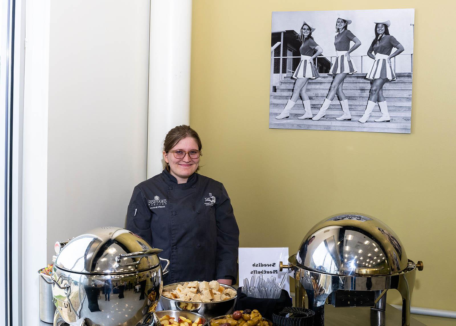 Event staff member smiling in front of Swedish Meatball serving station